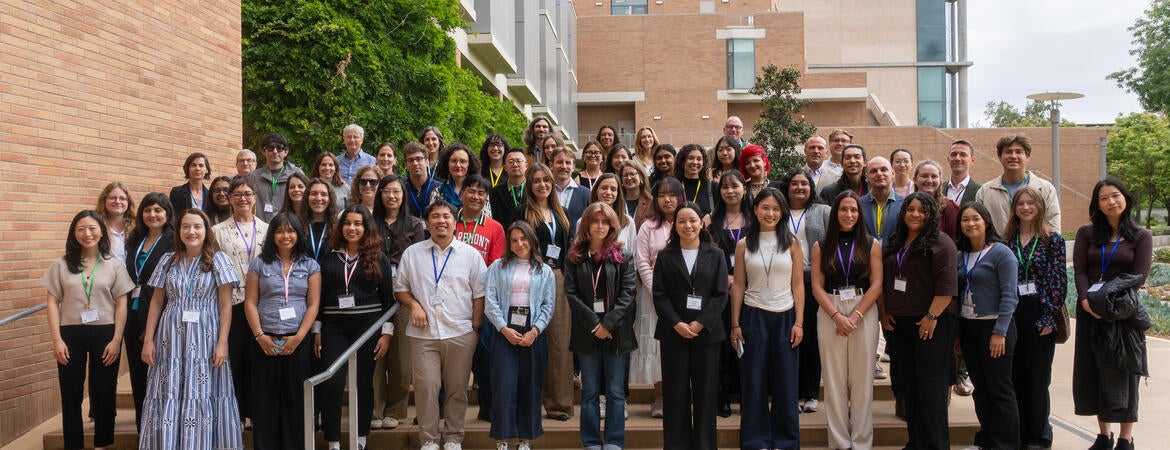 Dozens of California Well-Being Conference attendees pose for a group photo on outdoor steps between campus buildings at UC Riverside.