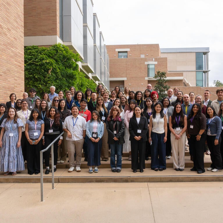 Dozens of California Well-Being Conference attendees pose for a group photo on outdoor steps between campus buildings at UC Riverside.