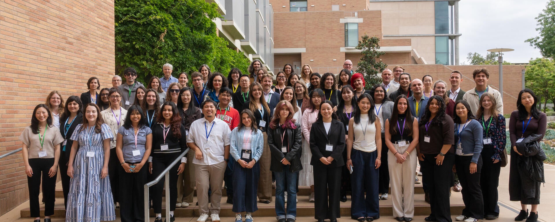 Dozens of California Well-Being Conference attendees pose for a group photo on outdoor steps between campus buildings at UC Riverside.