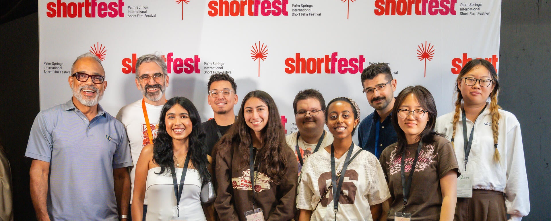 MCS and TFDP students enjoy their trip, smiling in front of the ShortFest backdrop.