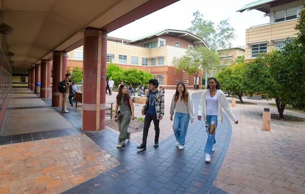 Students walking beneath the CHASS building at UC Riverside