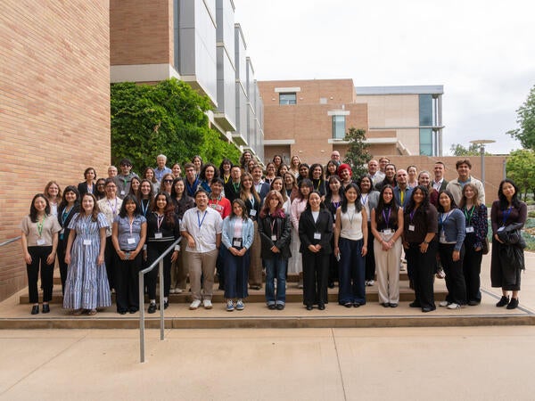 Dozens of California Well-Being Conference attendees pose for a group photo on outdoor steps between campus buildings at UC Riverside.