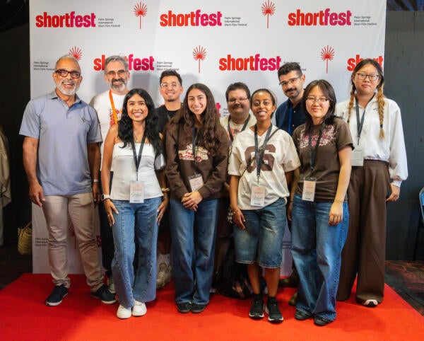 MCS and TFDP students enjoy their trip, smiling in front of the ShortFest backdrop.